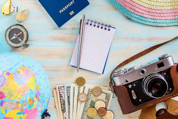 Travel accessories on blue wooden background old photocamera compass with passport and dollars