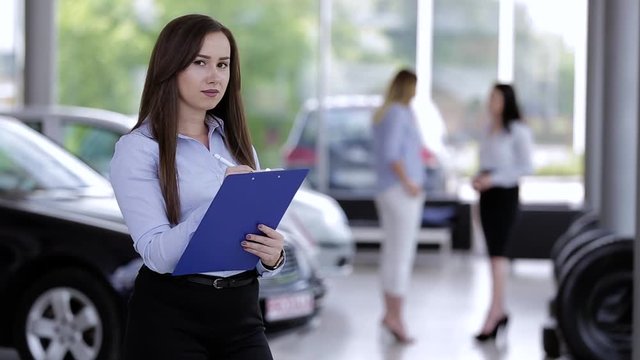 Young Optimistic Female Car Dealer Writing On Paperboard 