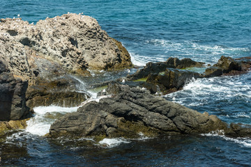 Blue sea, waves and rocky shore.