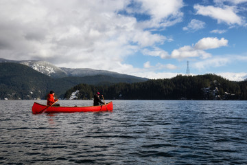 Girl and Man Canoeing during a sunny winter day. Taken in Indian Arm, Deep Cove, North Vancouver, British Columbia, Canada.