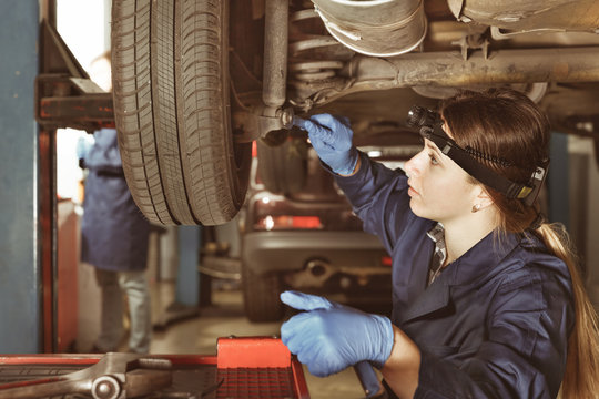 Female master is repairing car on her workplace