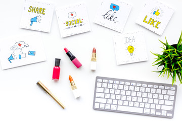 Female blogger concept. Work desk with keyboard, cosmetics and social media icons on white desk top view