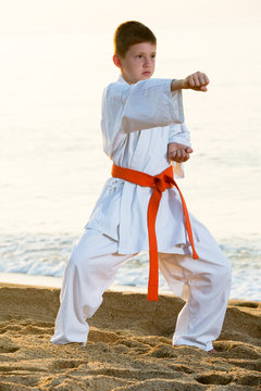 Boy practising karate at seaside