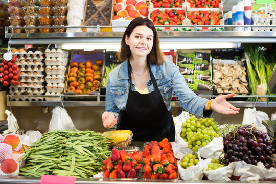 Female shopping assistant demonstrating assortment of grocery shop