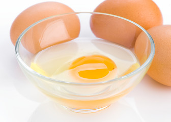 open egg in glass bowl on white background