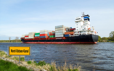 Containerschiff passiert den Nord-Ostsee-Kanal als Wirtschaftsweg zwischen Nordsee und Ostsee 