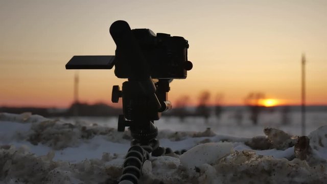 Dslr camera photographing winter landscape. Dslr camera shooting on a sunset with winter nature snow