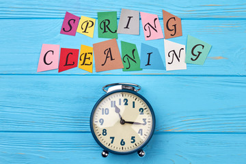 Time for clean up for spring. Blue alarm clock and colorful letters spring cleaning. Time for spring cleaning concept.