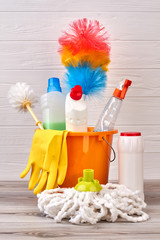 Variety of cleaning products in bucket. Detergent bottles, brushes, gloves and duster in bucket....