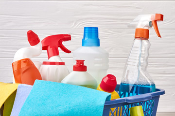Assortment of detergents in laundry basket. Close up variety of bottles with cleaning liquid. Hacks and tips for clean up your home.