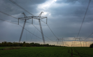  high-voltage power lines at sunset. greeb field.