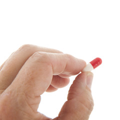 Capsules in red and white in hand