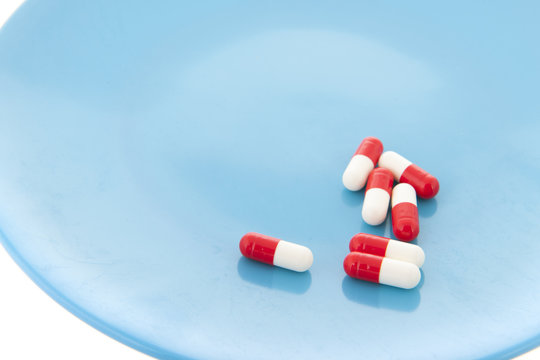 Capsules in red and white on plate