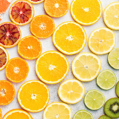 Fototapeta na wymiar Pattern, different varieties of citrus fruits, oranges, lemons, limes, kiwis arranged in the rows, diagonal, square. Colorful background, top view