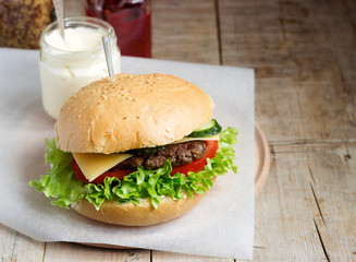 Homemade hamburger with fresh vegetables served with various sauces.