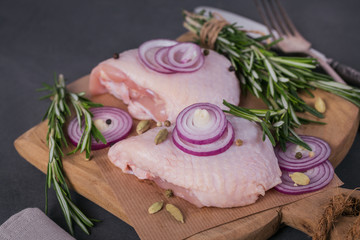 Raw chicken thighs with rosemary, red onion and peppercorns