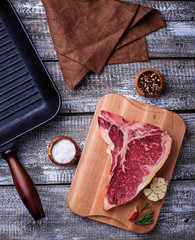 Raw T-bone steak and iron grill pan