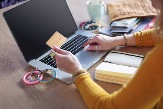 Young woman holding credit card and using laptop computer. Online shopping concept