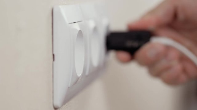Hand Putting Plug Into Electricity Socket usb device phone cell charge
