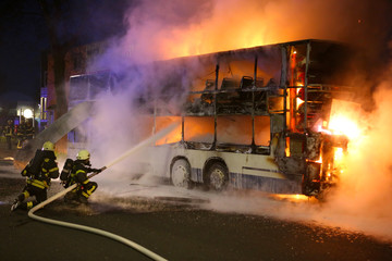 Feuerwehrleute löschen den Brand eines Doppeldecker-Busses