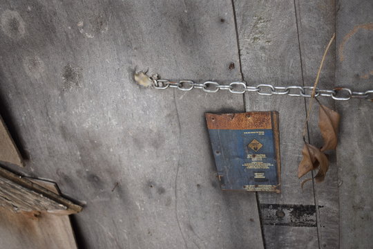 Portão velho de madeira trancado com corrente metálica