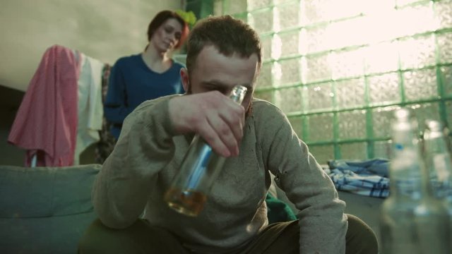 woman screams beats on a man an alcoholic sit on sofa drink beer feel sad stress fear alcoholic home desperate unhappy alcoholism alcohol angry nervous guy tired bottle slow motion close up portrait