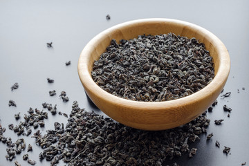 black tea leaves in a wooden bowl