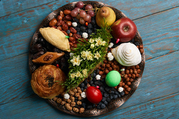 Novruz tray plate with Azerbaijan national pastry pakhlava , shekerbura, gogal and dry fruit snack on rustic table  background. spring new year celebration top view
