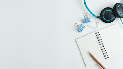 Styled stock photography white office desk table with blank notebook, keyboard, macaroon, supplies and coffee cup. Top view with copy space. Flat lay.