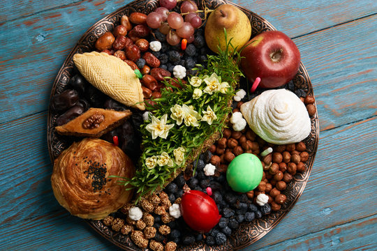 Novruz tray plate with Azerbaijan national pastry pakhlava , shekerbura, gogal and dry fruit snack on rustic table  background. spring new year celebration top view