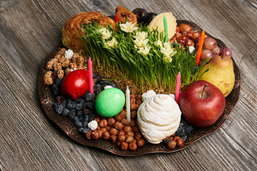 Novruz tray plate with Azerbaijan national pastry pakhlava , shekerbura, gogal and dry fruit snack on rustic table  background. spring new year celebration top view