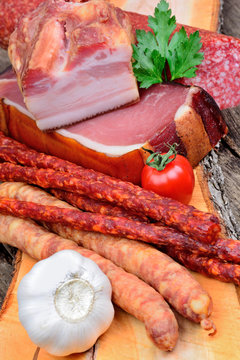 Cutting board with sausages, salami and bacon