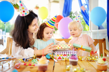 Little child and their mother celebrate birthday party with colorful decoration and cakes with colorful decoration and cake