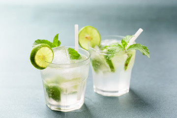 Glass of iced lemonade soda with slice lime and mint leaves, cold drink in summer