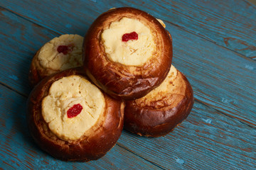 Round Russian scones with cottage cheese - vatrushka on rustic wooden table background, top view. Traditional Russian baking.