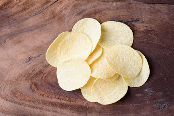 Potato chips on wooden background, top view