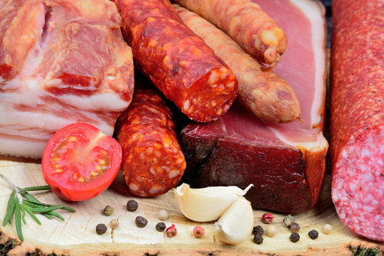 Sausages, smoked bacon and salami with spicy on table