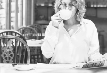 Business woman reading newspaper in the morning