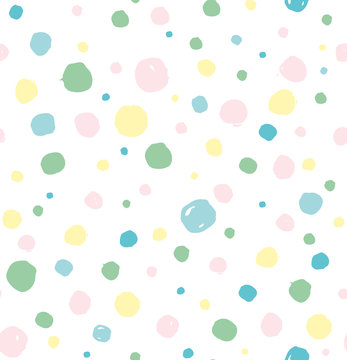 Seamless pattern of cute hand drawn light shades colored polka dots.