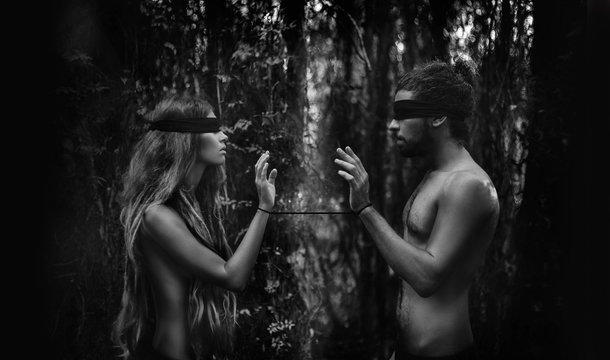 atrractive young man and woman with eyes closed. lost in forest concept