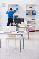 Handsome businessman employee sitting at his desk in office