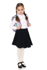Beautiful schoolgirl with a backpack behind her shoulders.