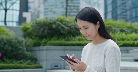 Woman sending sms on cellphone at outdoor