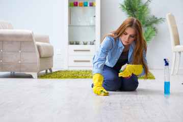 Young woman cleaning floor at home doing chores