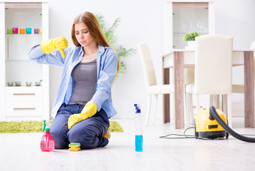 Young woman cleaning floor at home doing chores