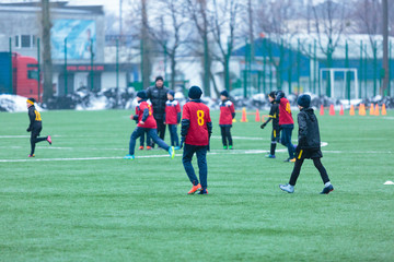 boys play football on the winter stadium