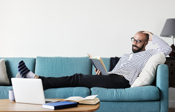 Bearded Man Reading On The Couch