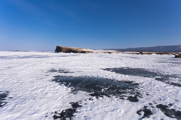 Lake Baikal in winter day. The ice near the cliffs of Haranci Island