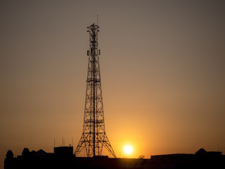 Silhouette high antenna in mid of city as background