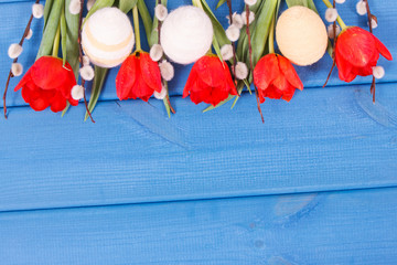 Fototapeta na wymiar Tulips, catkins and eggs wrapped woolen string as festive Easter decoration, copy space for text